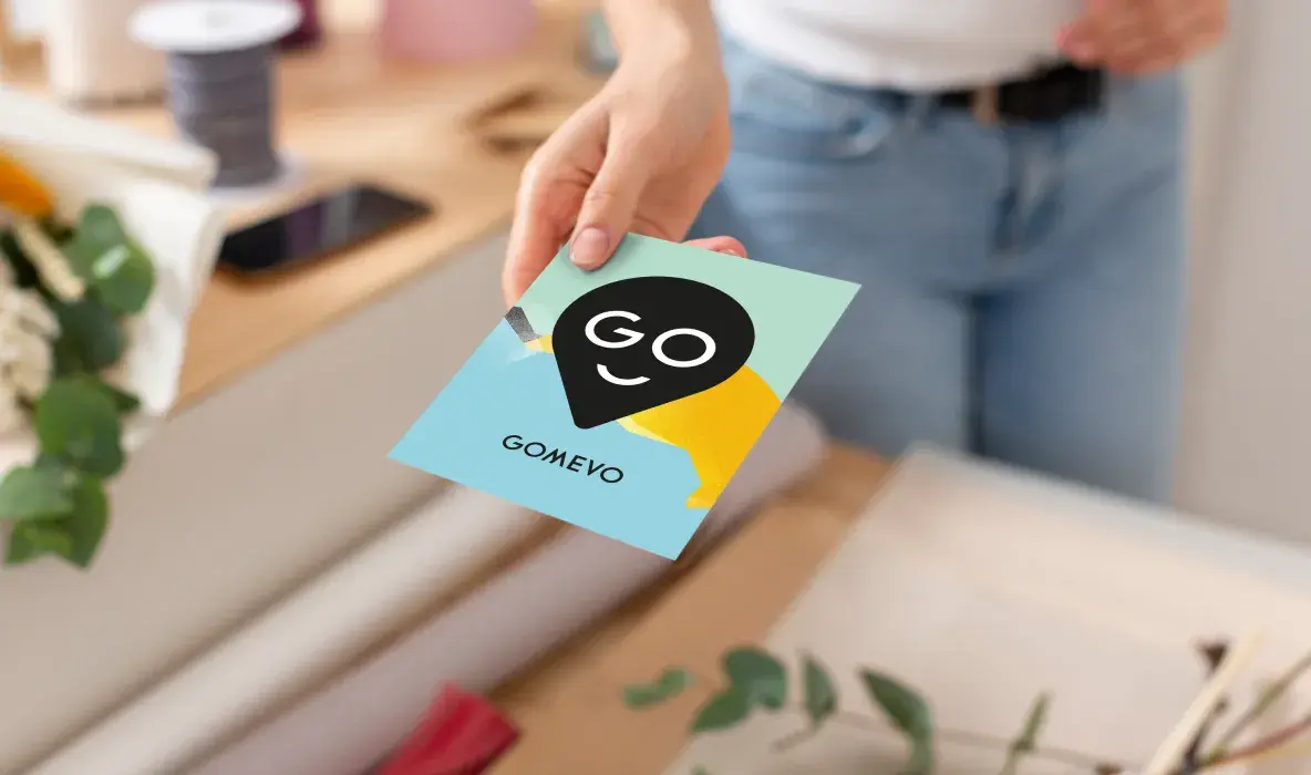 Verkäuferin gibt Postkarte als Geschenk beim Verkauf mit. Verkäuferin gibt Postkarte als Geschenk beim Verkauf mit.